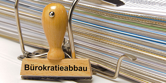 Stempel mit Bürokratieaufschrift vor Ordner