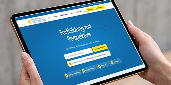 Eine Person hält ein Tablet in den Händen auf dem die Startseite des neuen Webauftritts des ZFZ Stuttgart zu sehen ist